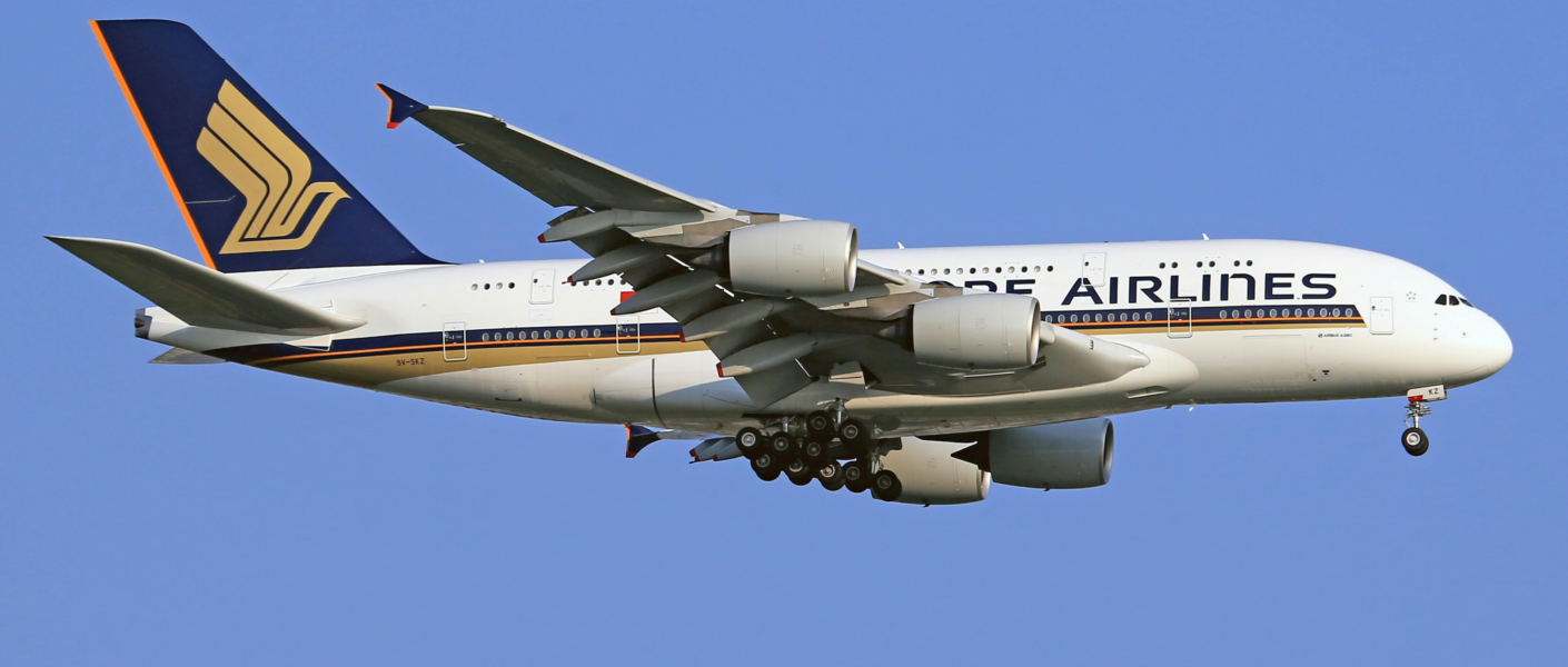 A Singapore Airlines Airbus A380 jet flying against a clear blue sky.